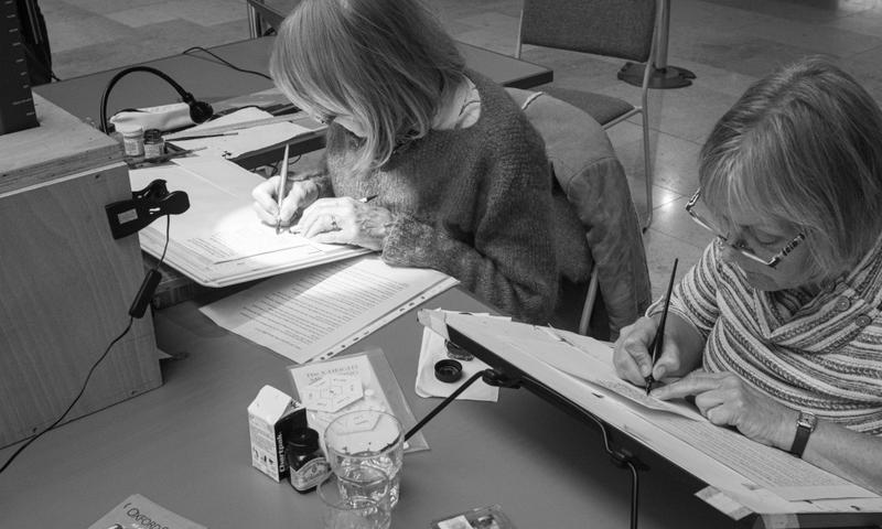 Two calligraphers work to copy an example of the Gutenberg Bible in the Bodleian Library's Script/Print/Code event.