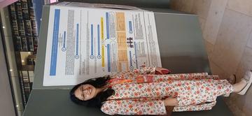 20240812 Maheen stands in front of a research poster
