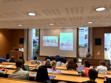 A lecture theatre - people are looking towards a slide on a projector in the background