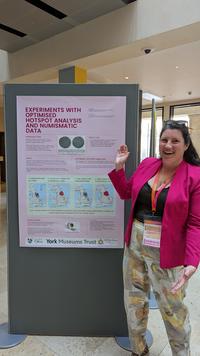 Photo of Lucy Moore in front of a poster